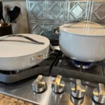 Hands-on testing image of Caraway Nonstick Ceramic Cookware Pots and pan with Lids on a stovetop for Caraway cookware reviews