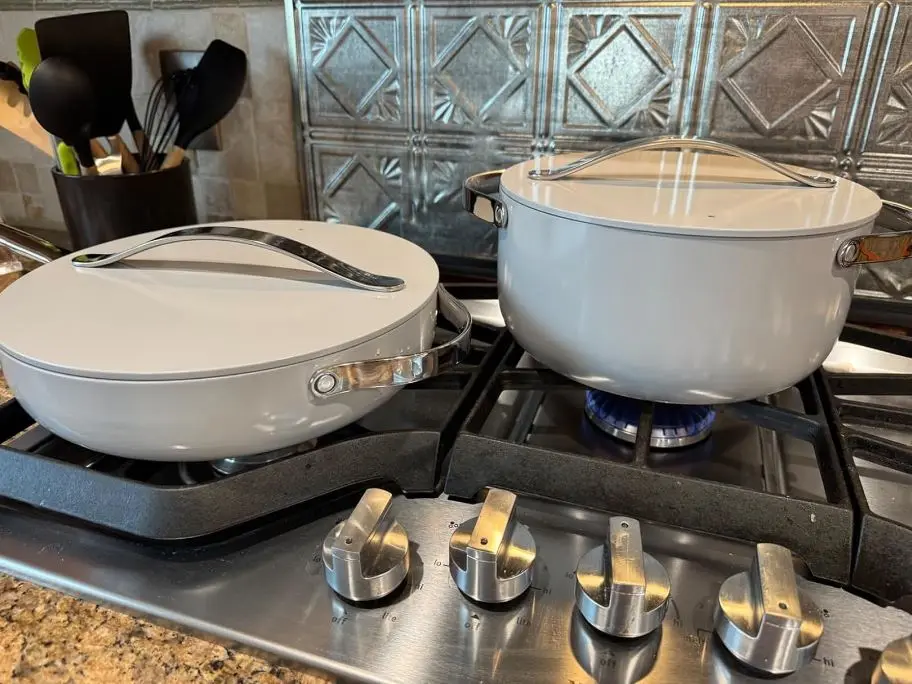 shown is real life review image of Caraway Nonstick Ceramic Cookware Set Pots, Pans with Lids on a stovetop being used